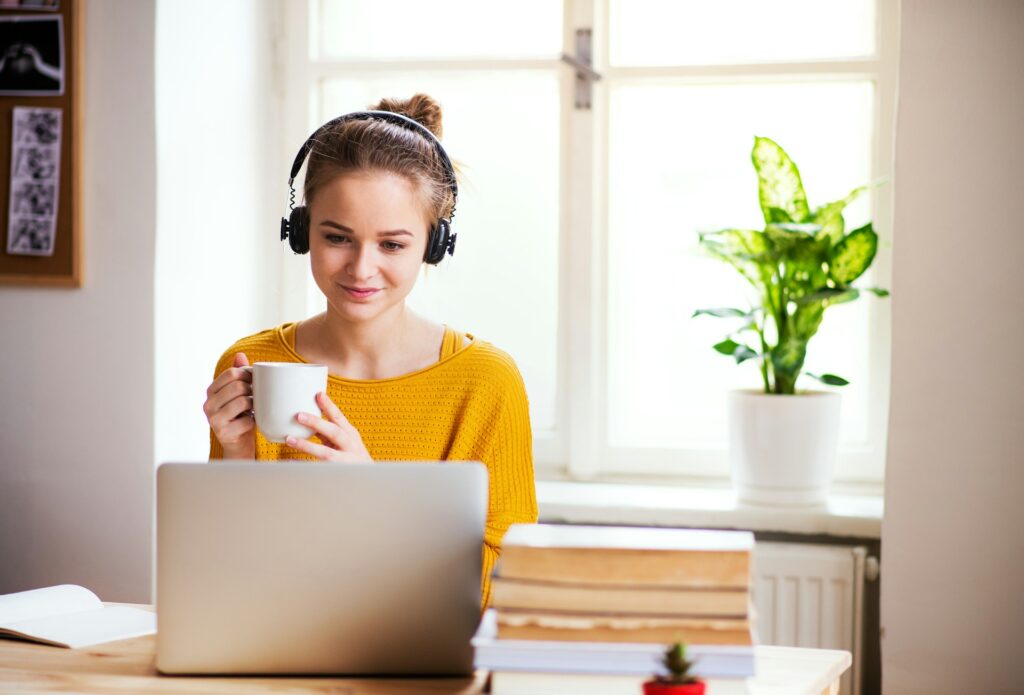 Teenage student studying Spanish online with laptop, books and headphones — GCSE Spanish revision tips